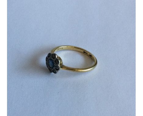 An 18 carat sapphire and diamond daisy head cluster ring in two colour gold. Approx. 3 grams. Est. £50 - £80.