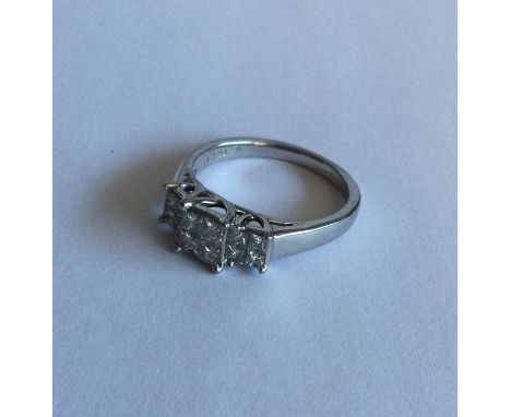 A diamond twelve stone princess cut cluster ring in 18 carat gold claw mount. Approx. 5 grams. Est. £100 - £200.