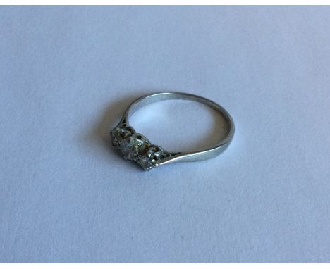 A platinum mounted three stone diamond ring. Approx. 3 grams. Est. £100 - £200.