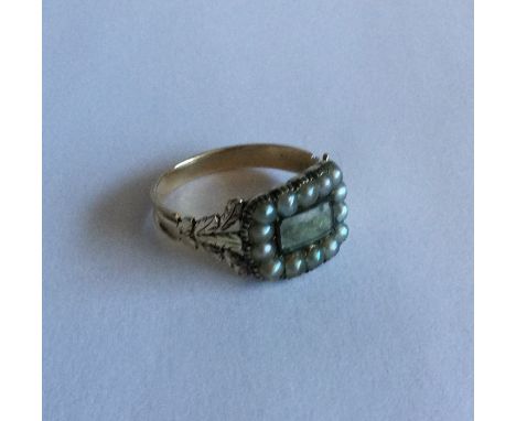 A Georgian gold mounted memorial ring with pearl border dated 1830 verso. Approx. 3 grams. Est. £60 - £80.