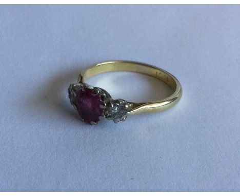 An attractive ruby and diamond three stone ring in 18 carat claw mount. Approx. 3 grams. Est. £150 - £200.