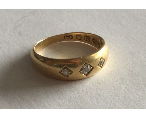 An 18 carat gold and diamond three stone gypsy set ring. Approx. 4 grams. Est. £60 - £80.