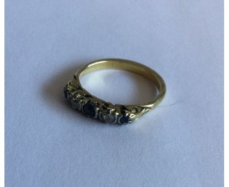 A sapphire and diamond five stone ring in carved 18 carat gold mount. Approx. 3 grams. Est. £50 - £80.