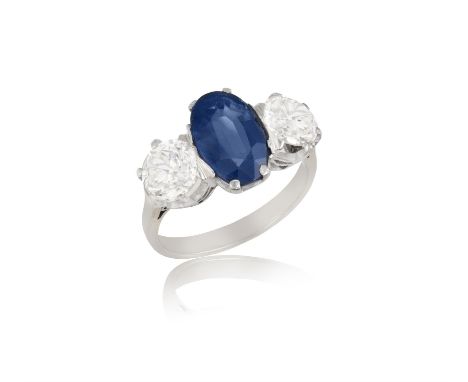 A Sapphire and diamond three-stone ringThe oval-shaped sapphire, claw set and flanked by two old-cut diamonds, estimated sapp