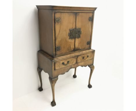 Georgian style walnut cocktail cabinet on stand, two cupboards enclosing glazed shelf above two drawers, cabriole legs on bal