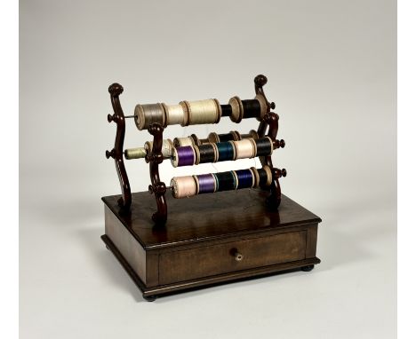 An early Victorian mahogany bobbin stand, of twin scroll-carved pairs of uprights, each fitted with two bars for suspending b