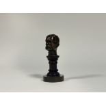 A desk-top bronze bust of Lord Kitchener, early 20th century, dark brown patina, mounted on a turned