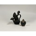 A bronze oil lamp, late 19th century, probably Nepal or Tibet, with gadrooned body, the handle and