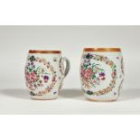 A graduated pair of Chinese Export famille rose porcelain mugs, c. 1800, of barrel form, decorated