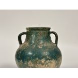 An Islamic, Kashan, glazed pottery twin-handled jar, probably 12th/13th century, with iridescent