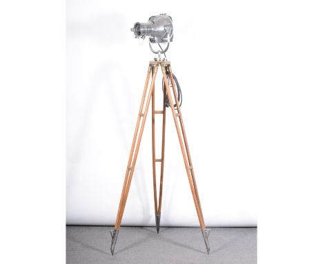A Strand Electric theatre spot light, on tripod adjustable stand, chrome, brass and steel mounts, height 184cm.