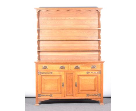An English Arts &amp; Crafts oak dresser, the gallery back above two short drawers, above pair of panelled cupboards separate