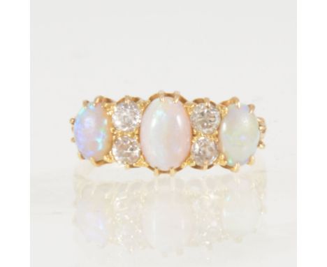 An opal and diamond half hoop ring, three oval cabochon cut opals claw set and spaced by four old cut diamonds arranged as tw