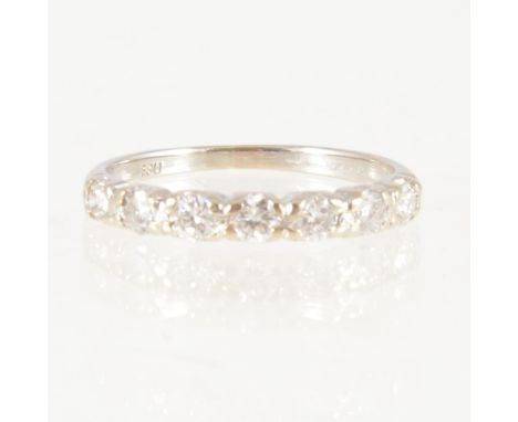 A diamond half eternity ring, seven brilliant cut diamonds claw set in an all white metal mount, width at front 2.7mm, ring s
