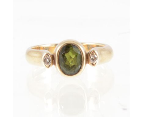 Tom Payne - A tourmaline and diamond three stone ring, the oval mixed cut green tourmaline collet set with a brilliant cut di