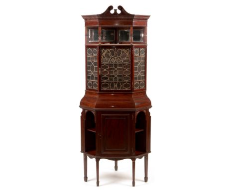 An impressive Edwardian mahogany corner cabinet on stand , the swan neck pediment and dentil moulded cornice above an open mi