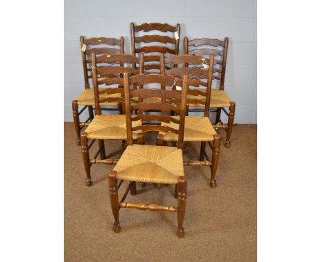 A group of 20th Century elm ladder back dining chairs, with woven rush seats, raised on turned legs, united by stretchers; to