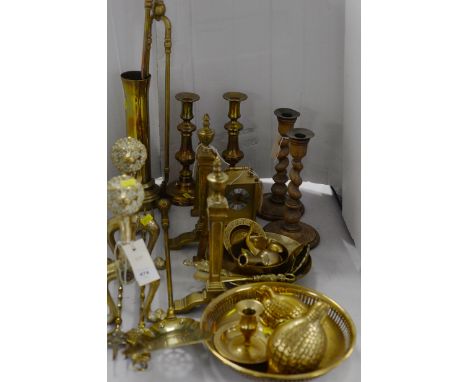 Brass fireside implements, to include: two pairs of andirons, one with lion head motif; brass quail; further fireside sets; c