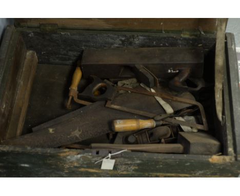 A vintage crate containing hand tools, to include: a plane; a mallet; various saws; and other tools.