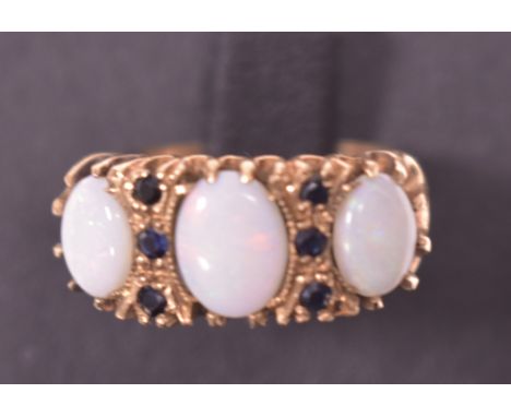 An opal and sapphire ring, the three oval opal cabochon parted by six sapphires, on 9ct gold shank, ring size O.