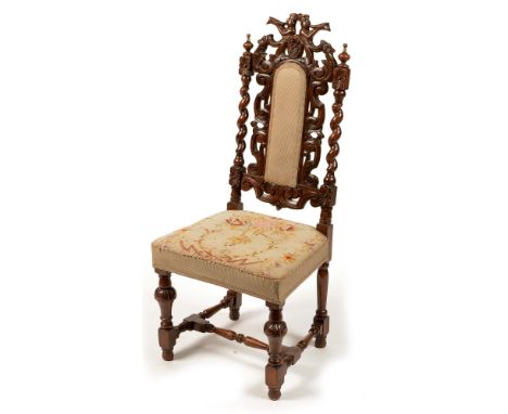 A Victorian carved oak side chair, in the 17th Century style, the top rail carved with figures playing horns, above a pierced