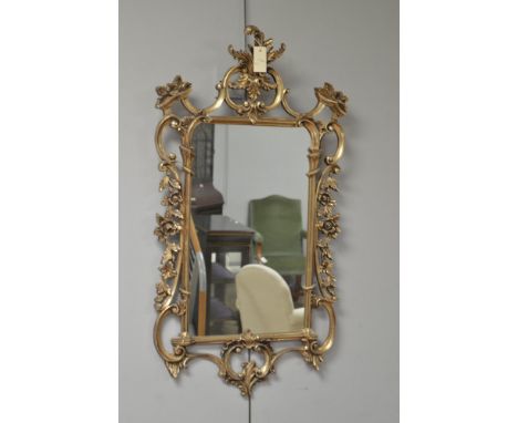 A carved and moulded Chippendale style gold-coloured mirror, 105 x 57cms wide.