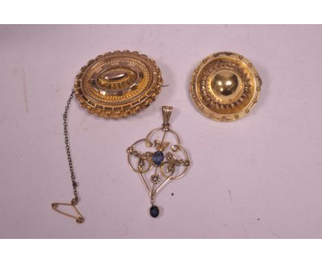 Two Victorian yellow metal Etruscan style roundel brooches; together with an Edwardian sapphire and seed pearl set pendant st