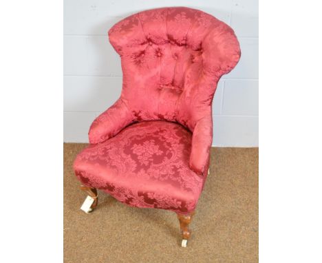 A Victorian nursing chair, upholstered in red satin, with button-back above a sprung seat, raised on squat walnut cabriole le