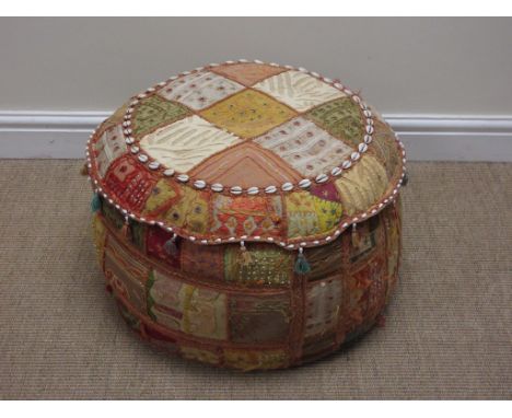 An antique patchwork and embroidered Pouffe with cowrie shell and tassel decoration, 21in D