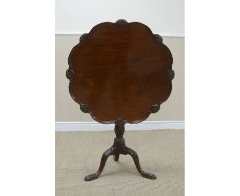 A Georgian mahogany Supper Table with shaped circular top having scalloped border, bird cage support baluster turned and carv