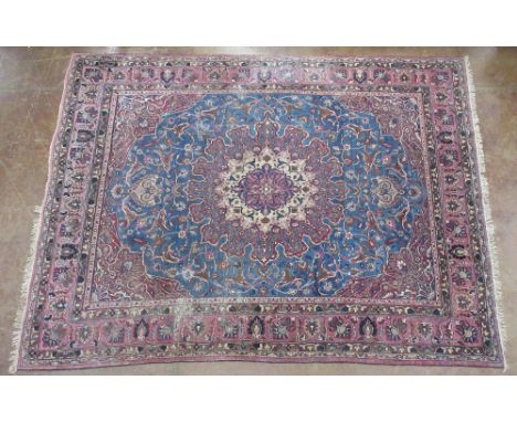 A bordered Persian Carpet with shaped oval medallion on a beige, blue and pink ground, 12ft x 9ft 3in, worn