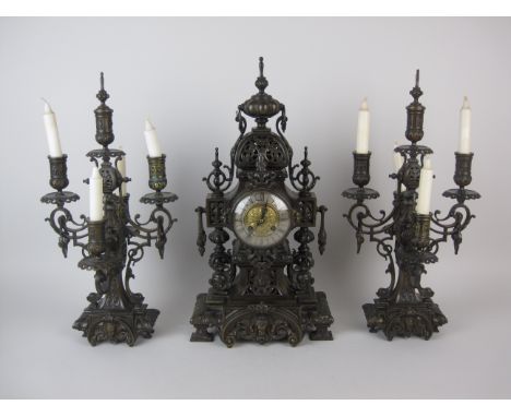 A Victorian Clock Garniture in bronzed metal, the clock with circular dial and French movement in pierced case, with pair of 
