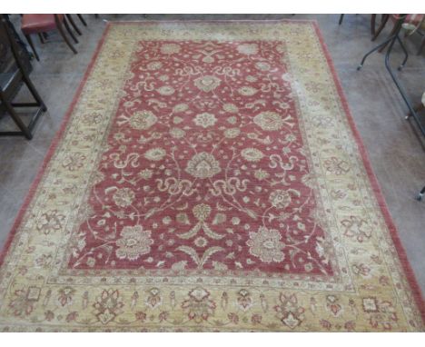 A bordered Feraghan Carpet with palmette and leafage scroll design on a rust ground, 14ft x 10ft