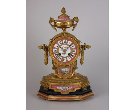 A 19th Century gilt metal Mantel Clock with urn finial and painted porcelain dial and panels depicting cherubs, all upon shap