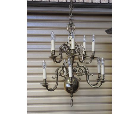 A Dutch brass two tier, twelve branch Chandelier of scroll design with bulbous base, 2ft D
