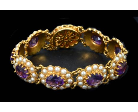 An Amethyst and Seed Pearl Bracelet having nine oval links each claw-set oval-cut amethyst within a frame of seed pearls in 9