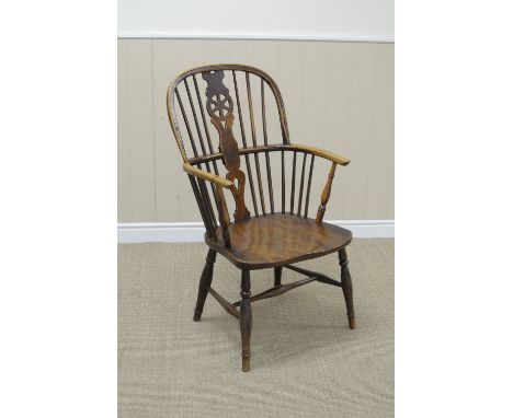 A 19th Century yew and elm Windsor Elbow Chair with pierced wheel and stick back, solid seat on turned supports united by H s