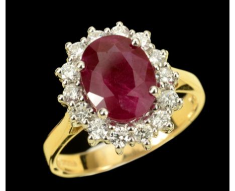 A Ruby and Diamond Cluster Ring claw-set oval-cut ruby, 2.13cts, within a frame of fourteen brilliant-cut diamonds in 18ct wh