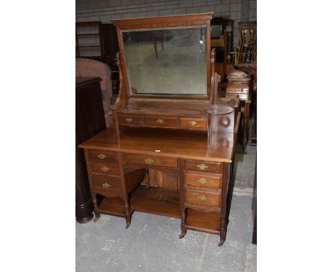 A late Victorian walnut dressing table, the rectangular beveled mirror above three small drawers, the base with an arrangemen