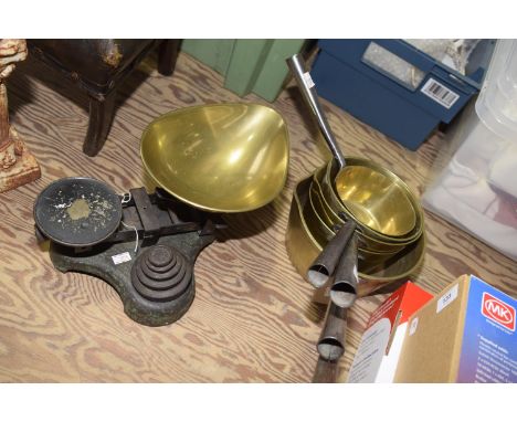 A set of brass graduated cooking pans Together with a set of vintage balance scales. 