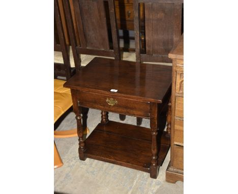 A good quality reproduction oak side table with a single drawer above a lower shelf. 