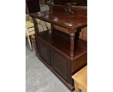 A Victorian mahogany dumb waiter with a single shelf above a pair of cupboard doors. 