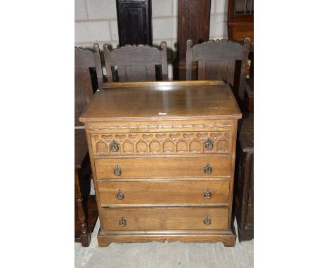 A reproduction oak Priory style chest of drawers on bracket feet. 
