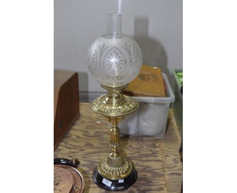 A brass effect oil lamp With frosted glass shade. 