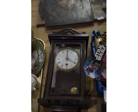 A wooden cased wall clock White enamel dial with Roman numerals. 