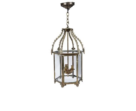 A GEORGIAN STYLE CAST BRASS HEXAGONAL LANTERN,with arched supports suspended from chain and circular corona, the body with gl
