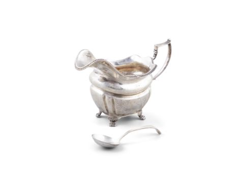 AN IRISH REGENCY SILVER HELMET-SHAPED CREAM JUG,Dublin c.1818, with beaded rim and angular handle, floral engraved sides with
