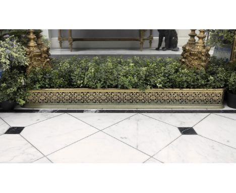 A PIERCED BRASS CURB FENDER, 19TH CENTURY,130cm wide