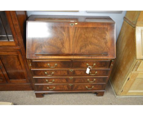 A reproduction mahogany bureau, the fall flap opening to reveal a fitted interior and leather writing surface, above two shor