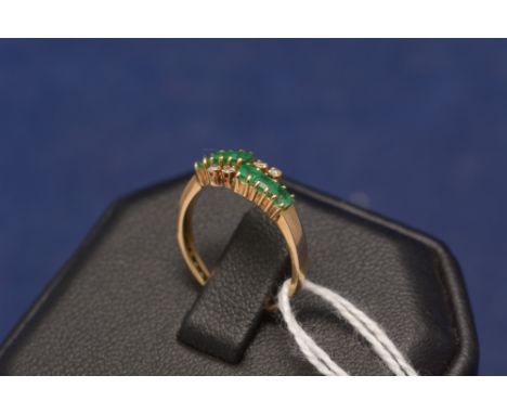 An emerald and diamond ring, the shank stamped '750'.